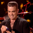 WATCH: Grimacing Robbie Williams uses hand-sanitiser immediately after touching audience at NYE gig