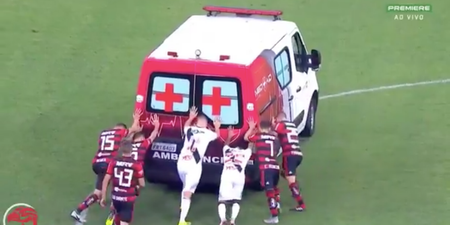 Ambulance breaks down on football pitch, players help to push it off
